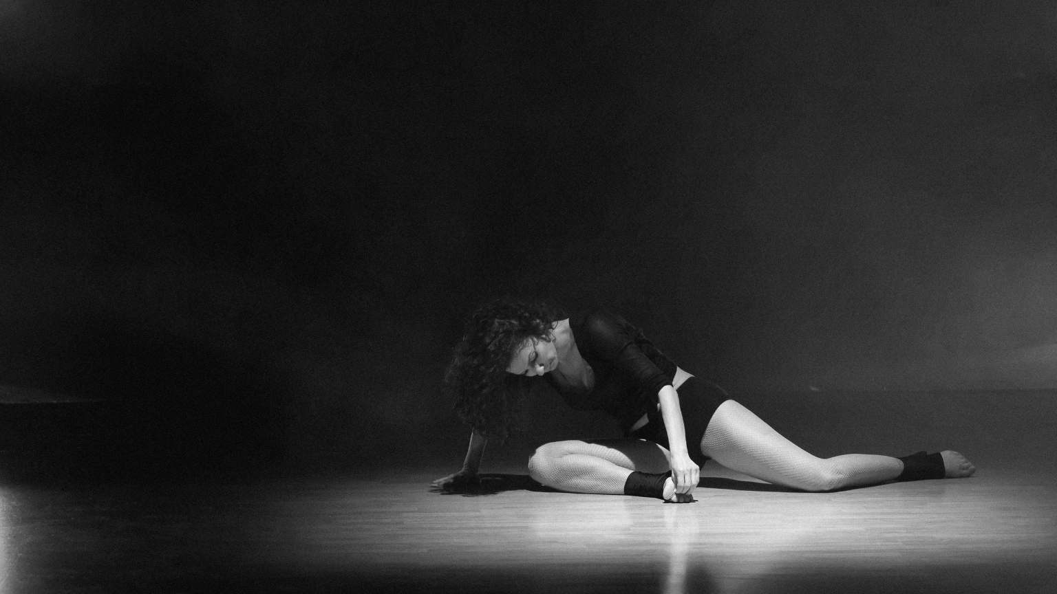 Mujer practicando danza contemporánea en estudio luminoso con movimiento libre y ropa cómoda