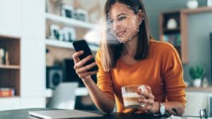 Persona siendo identificada mediante biometría facial en una pantalla digital con escaneo de documentos en segundo plano