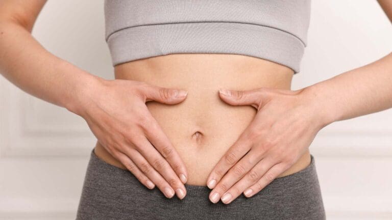 Mujer relajada en su hogar reflejando bienestar físico y emocional tras mejorar su salud digestiva mediante nutrición integrativa