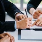 Pareja firmando un acuerdo de divorcio junto a un abogado, simbolizando el proceso de divorcio express y la asesoría legal especializada
