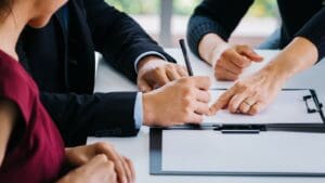 Pareja firmando un acuerdo de divorcio junto a un abogado, simbolizando el proceso de divorcio express y la asesoría legal especializada