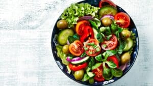 Ensalada gourmet con ingredientes frescos, cereales y vegetales de colores en vista cenital, lista para llevar.