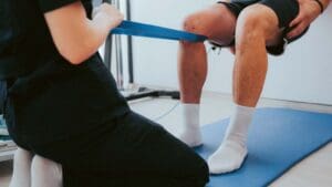 Fisioterapeuta aplicando tratamiento manual para recuperación de lesión muscular en paciente deportista