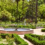 Vista de los Jardines de Murillo en Sevilla con arquitectura histórica y vegetación exuberante