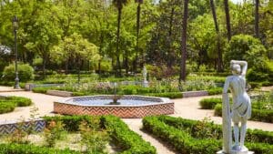 Vista de los Jardines de Murillo en Sevilla con arquitectura histórica y vegetación exuberante