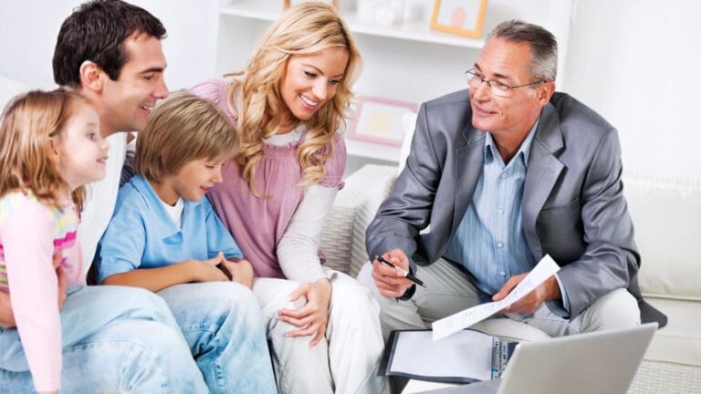 Familia española sonriente recibe asesoramiento sobre seguros de salud y vida con tranquilidad y confianza en una correduría profesional