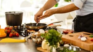 Hombre preparando recetas saludables fáciles en una cocina luminosa con ingredientes naturales y comida casera creativa