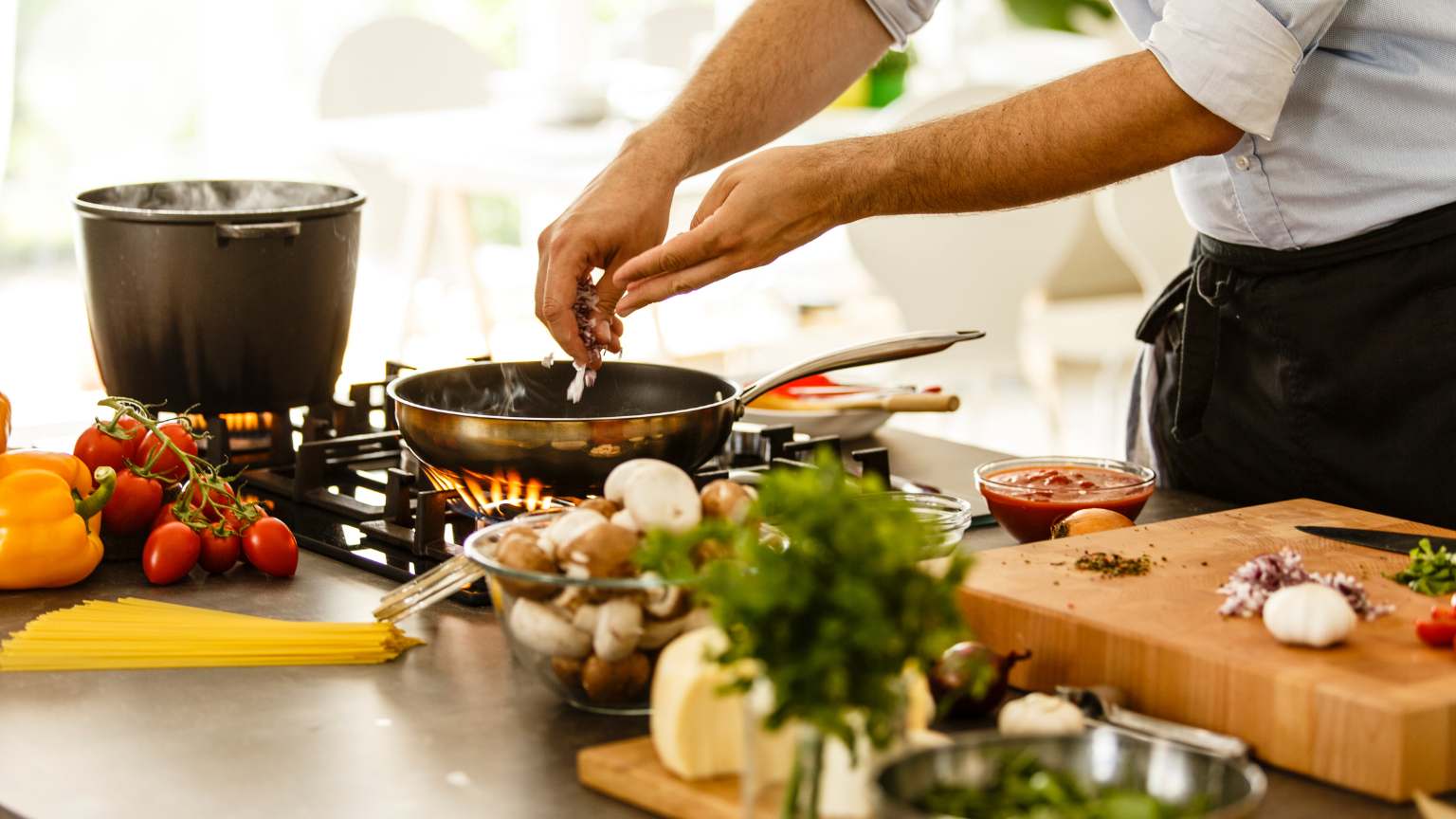 Hombre preparando recetas saludables fáciles en una cocina luminosa con ingredientes naturales y comida casera creativa