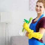Persona realizando limpieza ecológica en casa con productos sostenibles y reutilizables para cuidar el medio ambiente.