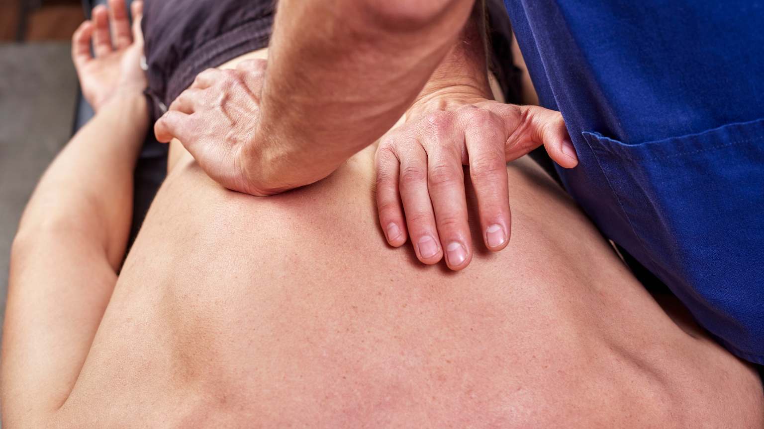 Tratamiento osteopático manual aplicado por profesional en consulta para mejorar el bienestar físico del paciente