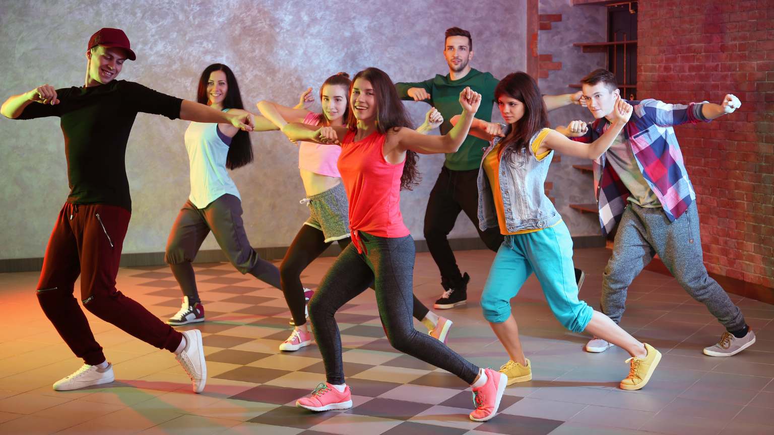 Adultos aprendiendo a bailar en grupo dentro de una academia, expresando felicidad y bienestar en un entorno relajado y profesional