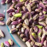 Pistachos crudos ecológicos en cuenco de madera sobre fondo claro como snack saludable y natural para una dieta equilibrada