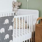 Habitación de bebé con cuna decorada con ropa de cama de algodón orgánico y detalles infantiles naturales