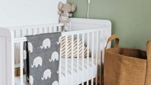 Habitación de bebé con cuna decorada con ropa de cama de algodón orgánico y detalles infantiles naturales