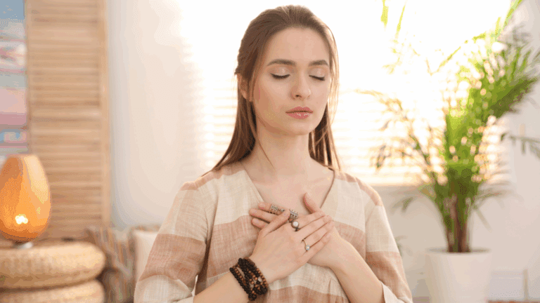 Mujer con los ojos cerrados y las manos sobre el pecho, en un gesto de conexión interior y amor propio, representando la calma y la fuerza del amor incondicional.