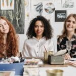 Artistas migrantes trabajando juntos en un taller de arte comunitario en Madrid como parte de programas de integración artística