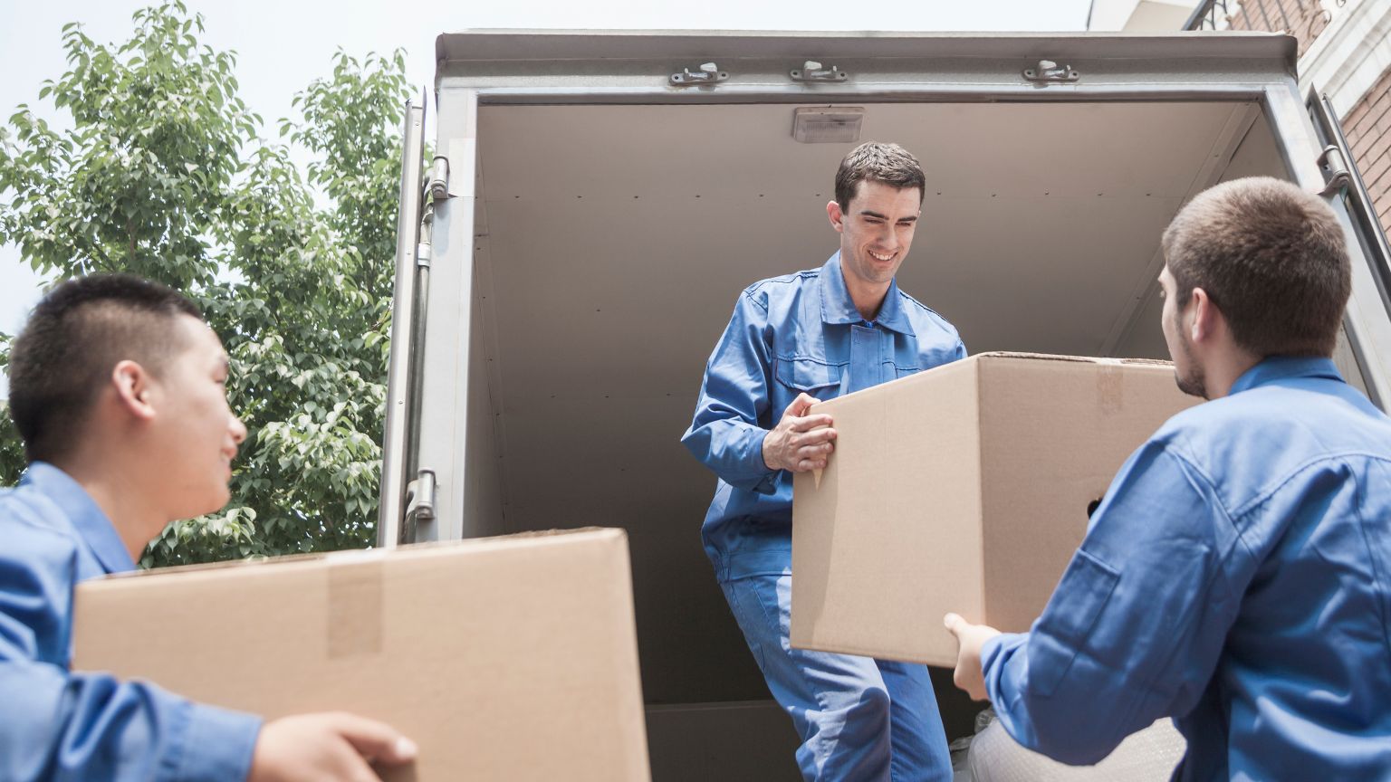 Trabajadores profesionales de mudanzas organizando cajas con cuidado y seguridad