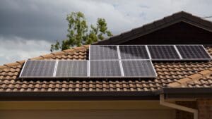 Vista de una casa moderna equipada con paneles solares y entorno natural que refleja sostenibilidad y eficiencia energética