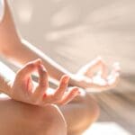 Mujer practicando yoga oncológico en ambiente tranquilo durante recuperación