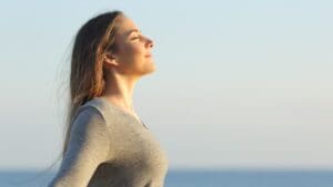 Mujer en un entorno tranquilo, meditando al aire libre, simbolizando la recuperación emocional y el equilibrio mental tras una crisis emocional.