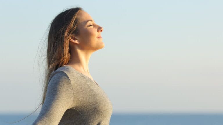 Mujer en un entorno tranquilo, meditando al aire libre, simbolizando la recuperación emocional y el equilibrio mental tras una crisis emocional.