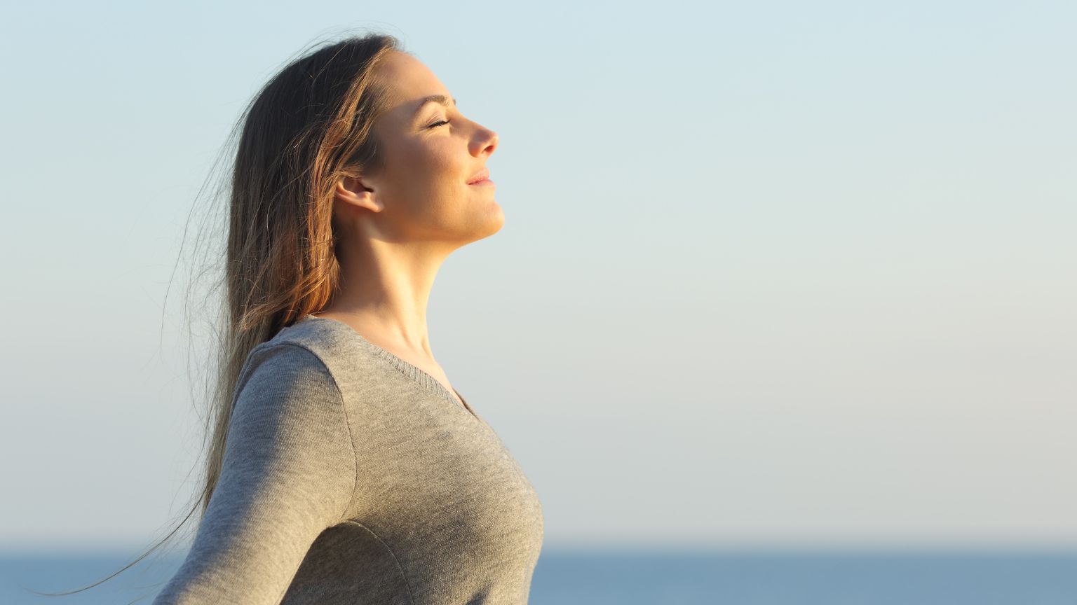 Mujer en un entorno tranquilo, meditando al aire libre, simbolizando la recuperación emocional y el equilibrio mental tras una crisis emocional.