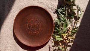 Delantal de lino hecho a mano, accesorios de cerámica y artesanía catalana sostenible sobre una mesa de madera