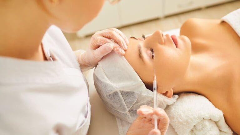 mujer recibiendo tratamiento estético facial con aguja o inyección en clínica estética, carboxiterapia, estética profesional, luz suave, primer plano