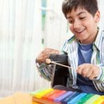 Niño pequeño participando en una sesión de musicoterapia con instrumentos.
