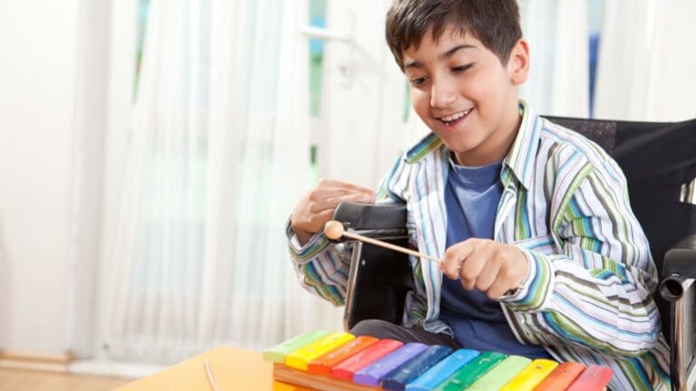 Niño pequeño participando en una sesión de musicoterapia con instrumentos.
