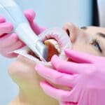 Dentista usando escáner intraoral en consulta con tecnología de odontología digital