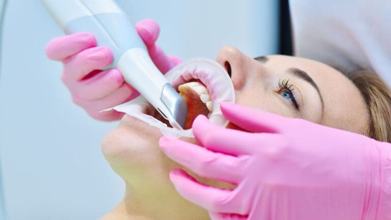 Dentista usando escáner intraoral en consulta con tecnología de odontología digital
