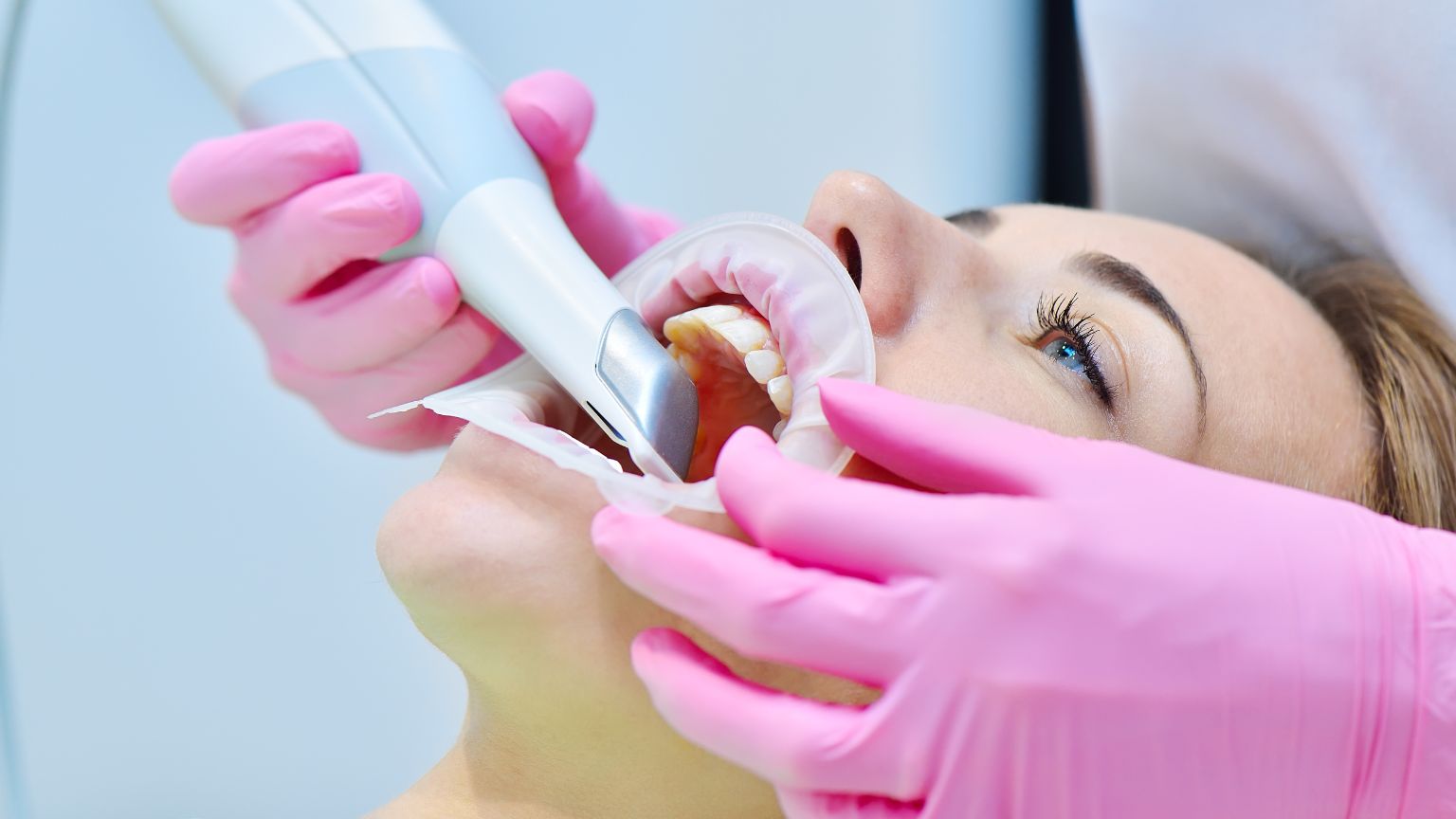 Dentista usando escáner intraoral en consulta con tecnología de odontología digital