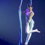 Artista de circo contemporáneo realizando una acrobacia aérea en un espectáculo escénico