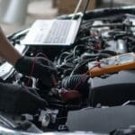 Técnico especializado realizando reprogramación de la centralita de un vehículo para mejorar el rendimiento del motor.