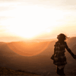Mujer con expresión serena en un paisaje natural, simbolizando paz interior, libertad emocional y conexión con su proceso de sanación.