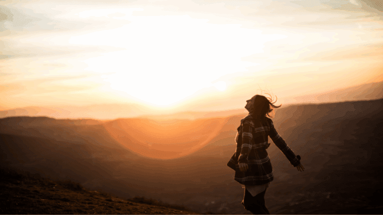 Mujer con expresión serena en un paisaje natural, simbolizando paz interior, libertad emocional y conexión con su proceso de sanación.