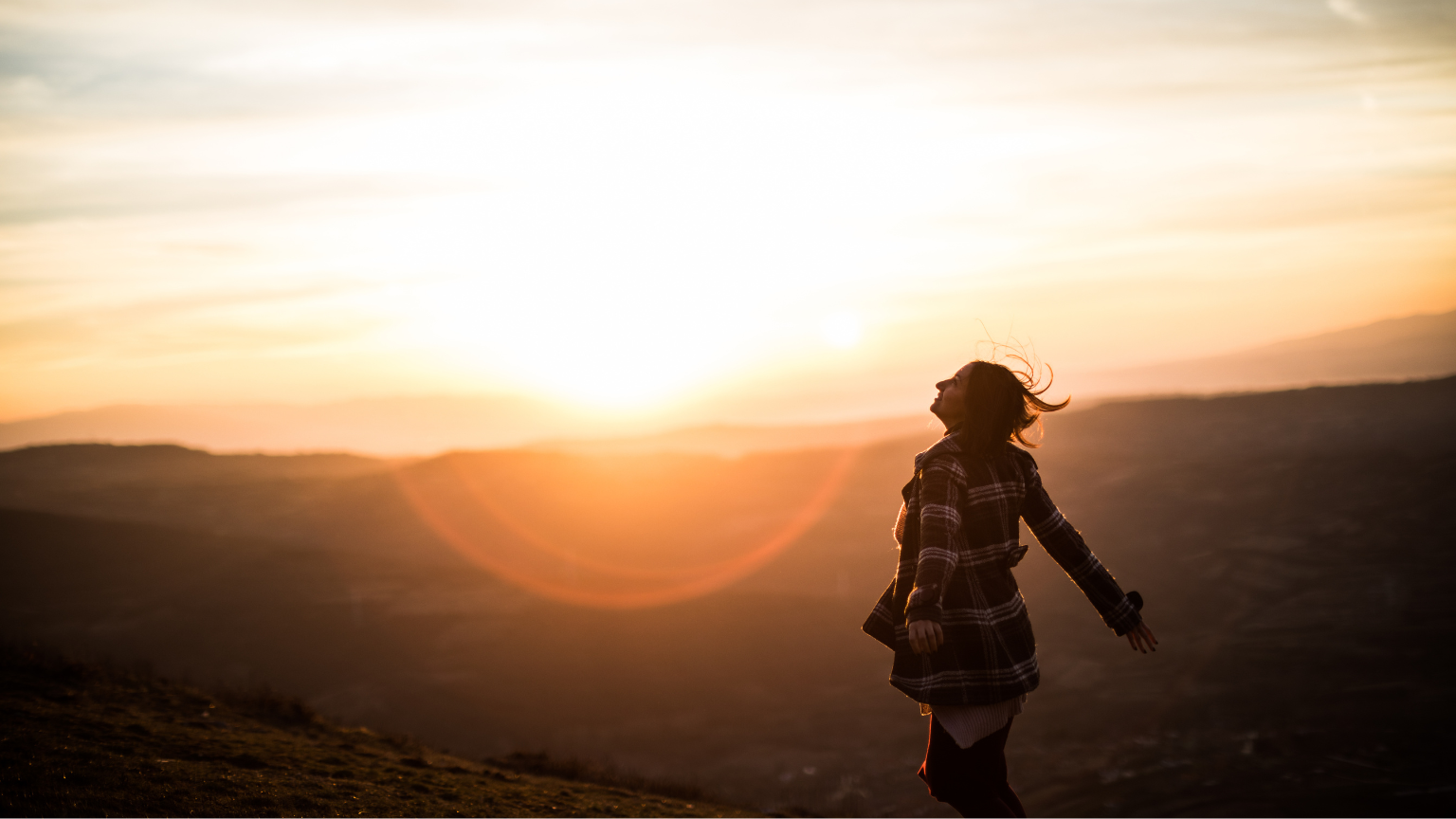 Mujer con expresión serena en un paisaje natural, simbolizando paz interior, libertad emocional y conexión con su proceso de sanación.