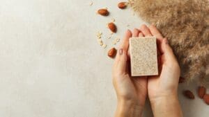 Jabón natural artesanal sobre fondo claro, con ingredientes ecológicos y presentación sin plásticos, ideal para piel sensible.