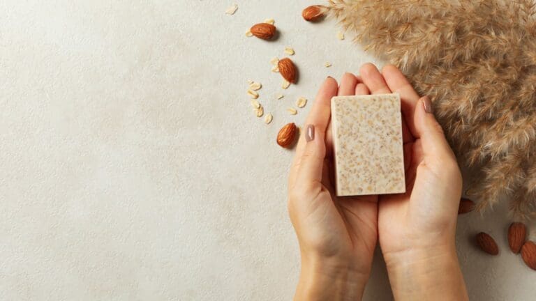 Jabón natural artesanal sobre fondo claro, con ingredientes ecológicos y presentación sin plásticos, ideal para piel sensible.