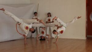 Personas practicando capoeira en grupo con actitud relajada y expresiva