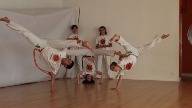 Personas practicando capoeira en grupo con actitud relajada y expresiva