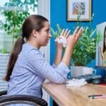 Mujer adulta en videollamada desde casa durante una sesión de terapia online, con expresión tranquila y entorno acogedor.