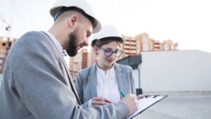 Ingenieros revisando planos técnicos en un local, gestionando documentación para obtener una licencia de actividad en Barcelona o Cataluña.