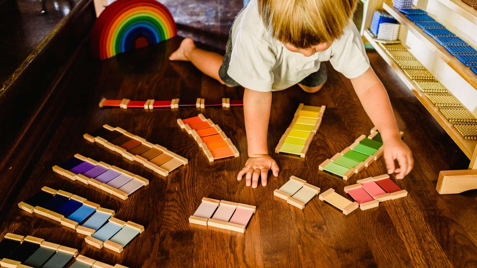 Niño jugando con juguetes Montessori de madera adecuados a su edad