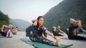 Personas practicando distintos tipos de yoga al aire libre en grupo, representando niveles y energías diferentes en un entorno natural y espiritual.