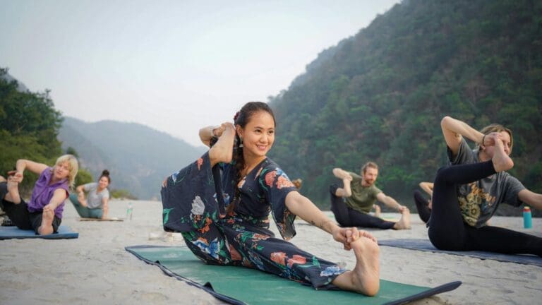 Personas practicando distintos tipos de yoga al aire libre en grupo, representando niveles y energías diferentes en un entorno natural y espiritual.