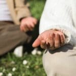 Persona practicando meditación al aire libre, simbolizando el poder del autocuidado, el bienestar emocional y el impacto positivo de una mentalidad saludable en la vida diaria.