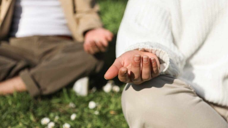Persona practicando meditación al aire libre, simbolizando el poder del autocuidado, el bienestar emocional y el impacto positivo de una mentalidad saludable en la vida diaria.