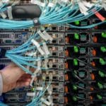 Técnico revisando cableado estructurado en servidor. Mantenimiento informático en centros de datos para garantizar conectividad y rendimiento continuo.